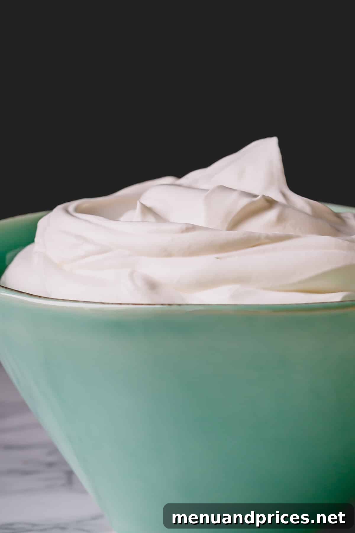 Cloud-Like Homemade Whipped Cream 7 A large serving bowl overflowing with beautifully peaked homemade yogurt whipped cream, ready for garnishing desserts.