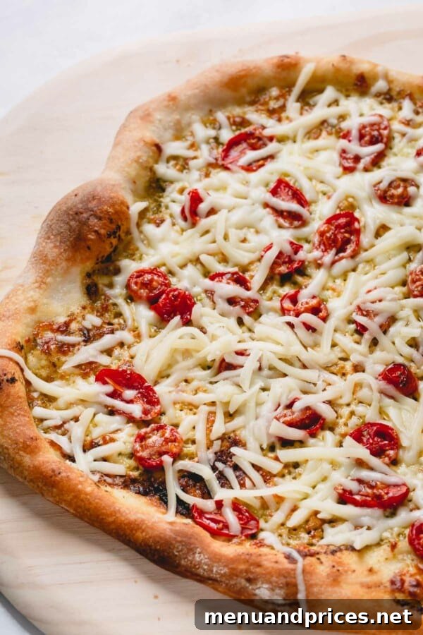 Slow-Roasted Tomato & Golden Mozzarella Pizza 5 A whole cheesy pesto pizza, perfectly baked with a golden crust and bubbling mozzarella, resting on a pizza peel, ready to be served.