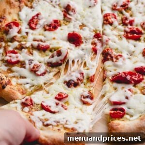 Slow-Roasted Tomato & Golden Mozzarella Pizza 9 Sliced pesto cherry tomato pizza with cheese pull.