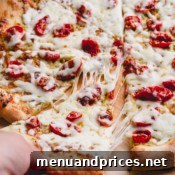 Slow-Roasted Tomato & Golden Mozzarella Pizza 10 Sliced pizza with cheese pull.
