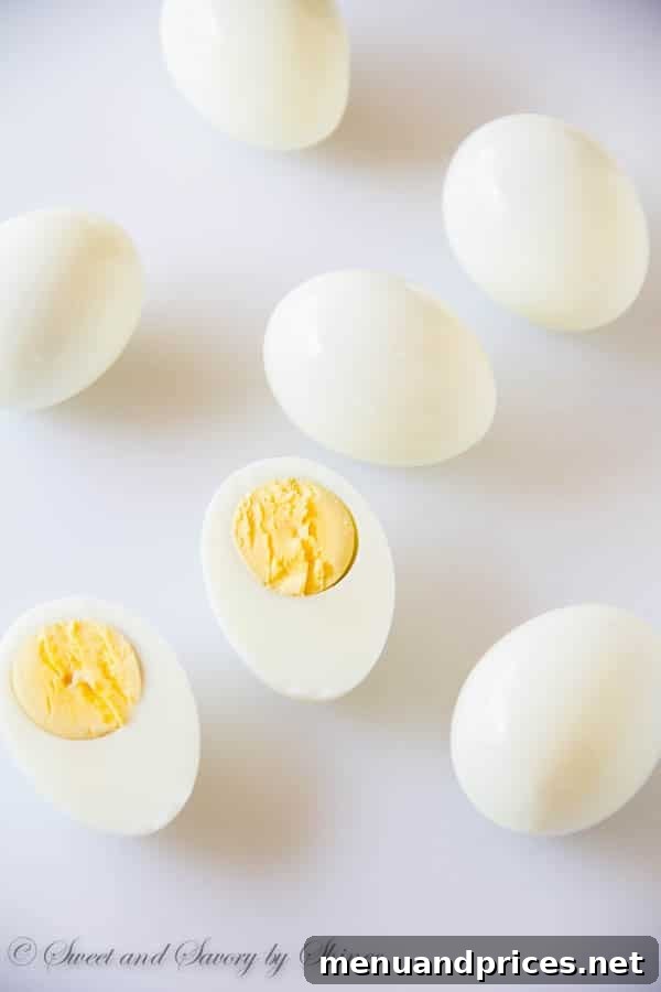Perfectly halved hard-boiled eggs with bright yellow yolks, showcasing ideal cooking for deviled eggs.