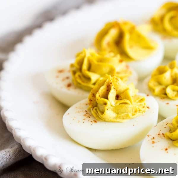 A close-up of a bowl filled with creamy curry egg yolk filling, ready to be piped into egg whites.