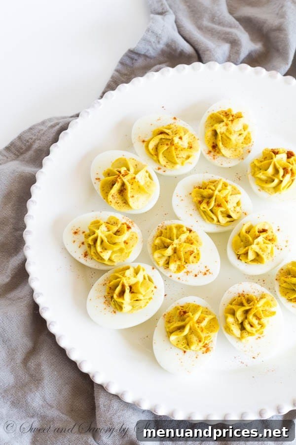 A serving platter showcasing multiple curry deviled eggs, perfectly garnished with smoked paprika.
