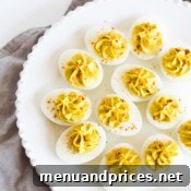 A final close-up shot of a single curry deviled egg, emphasizing its texture and garnishes.