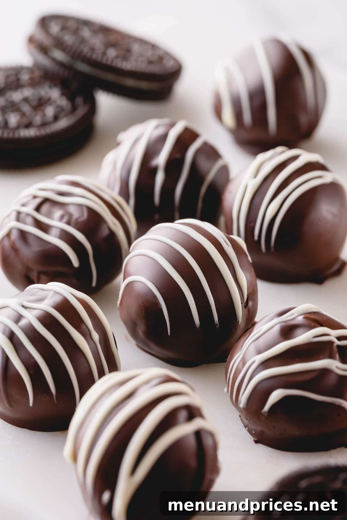 Dark chocolate Oreo balls with white chocolate drizzle, ready to be served.