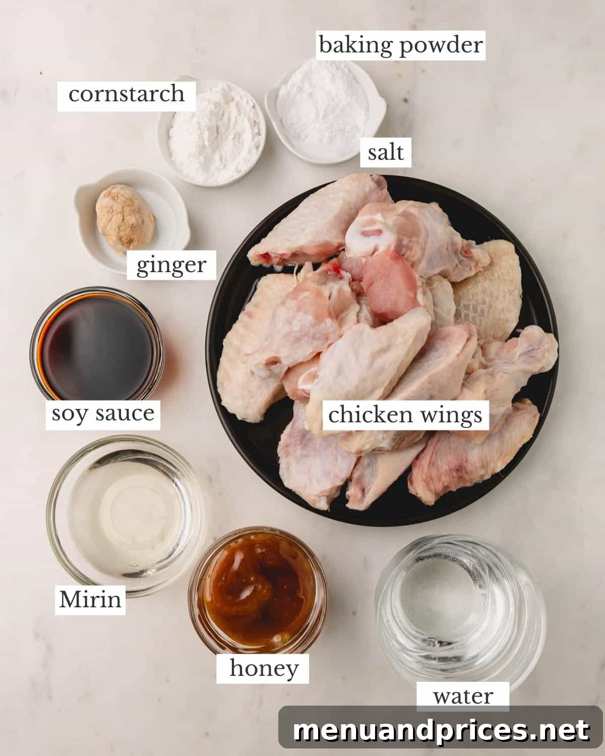 Sticky Teriyaki Chicken Wings 5 A curated display of all the essential ingredients for honey teriyaki chicken wings, including whole chicken wings, baking powder, soy sauce, mirin, honey, fresh ginger, and cornstarch, neatly arranged for preparation.