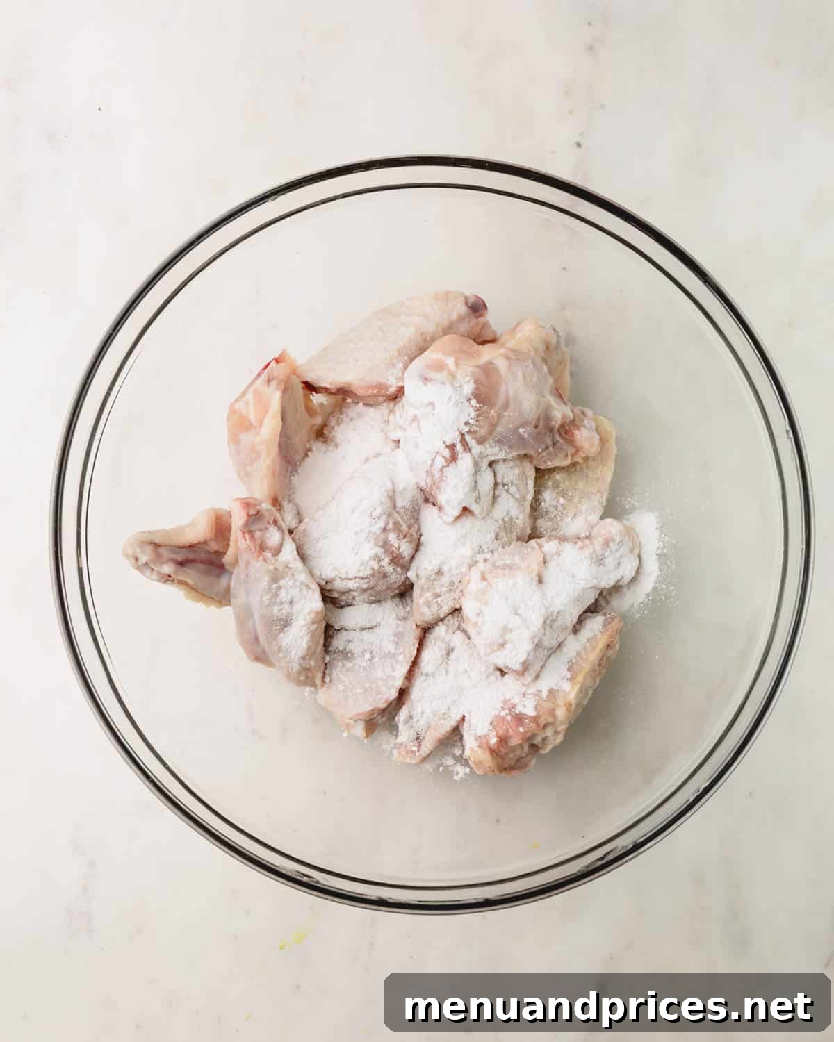 Sticky Teriyaki Chicken Wings 7 Raw chicken wings coated with baking powder and salt, arranged on a wire rack over a foil-lined baking sheet, ready for the oven.