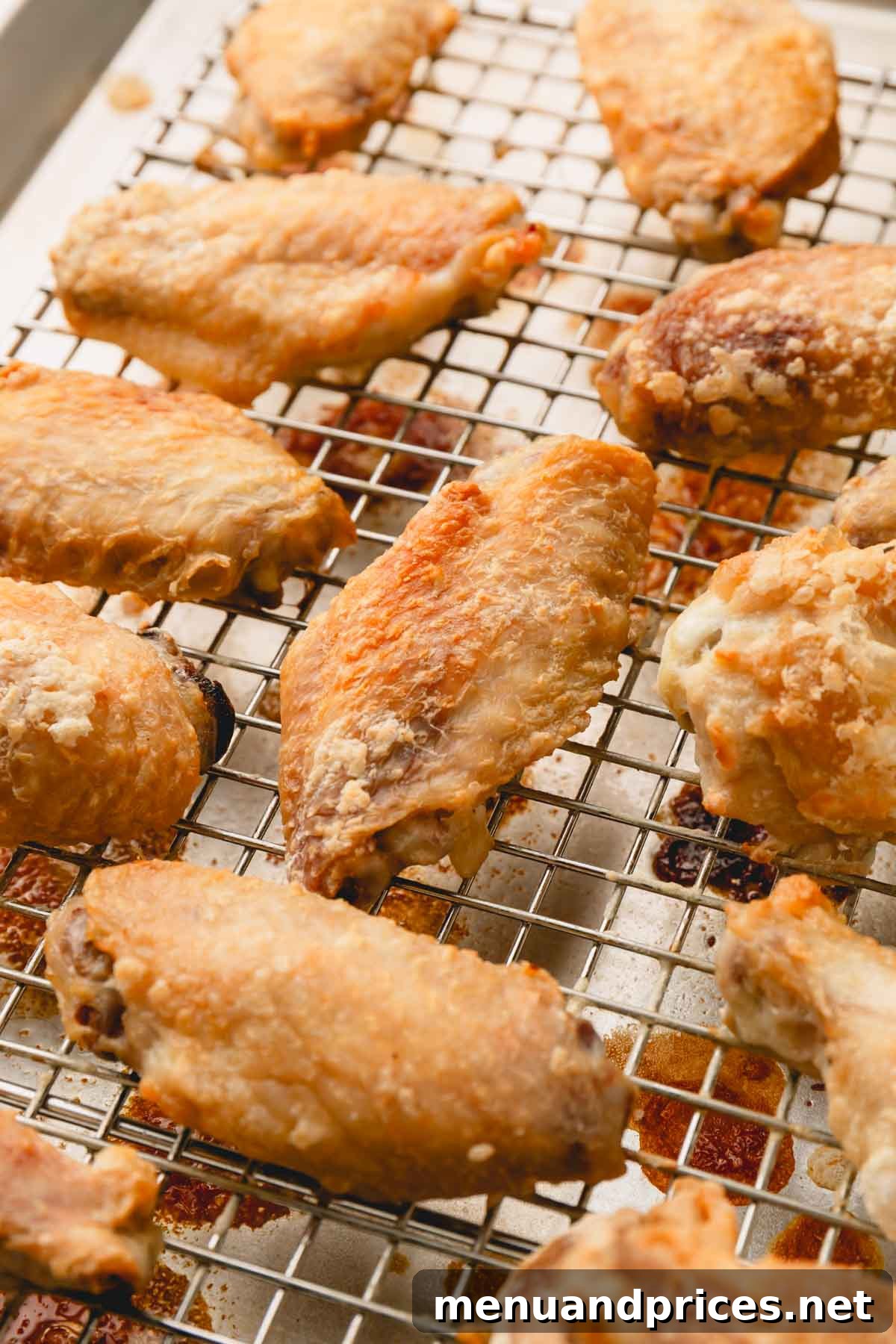 Sticky Teriyaki Chicken Wings 8 Freshly baked, golden-brown chicken wings cooling on a wire rack, showcasing their crispy texture after coming out of the oven.