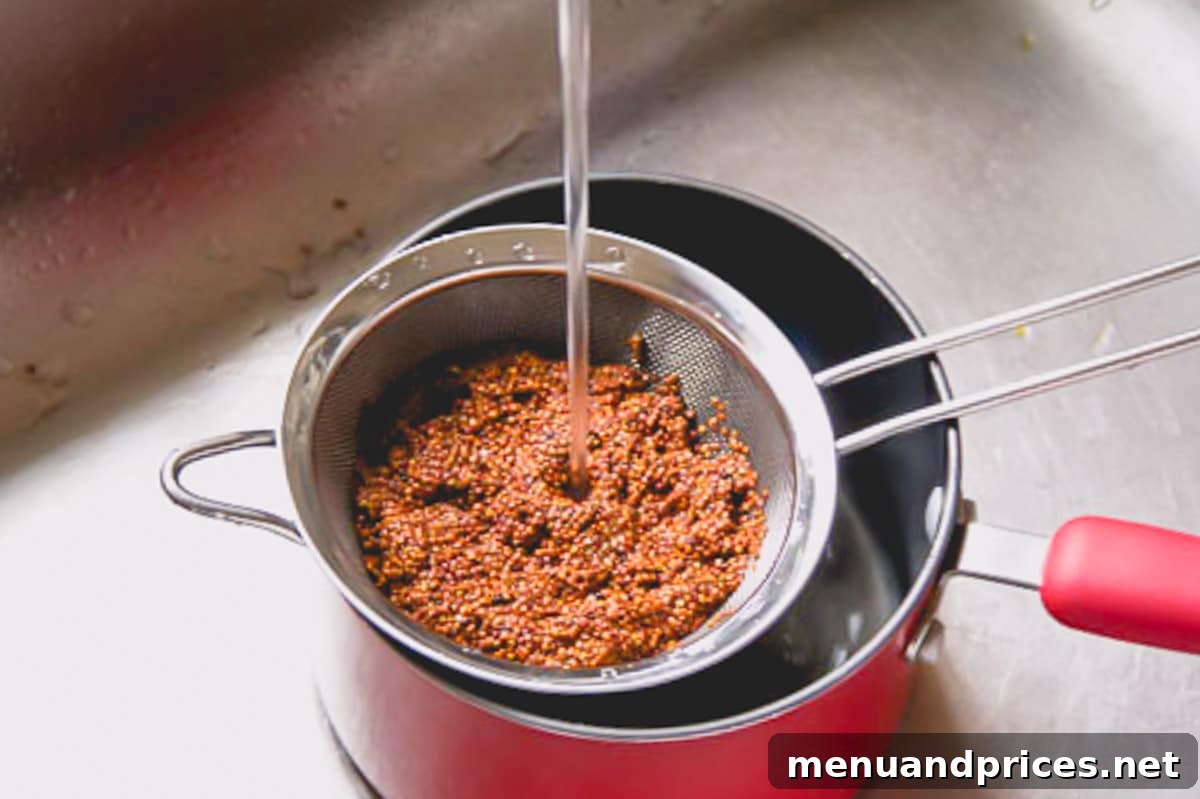 Roasted Brussels Quinoa Harvest Bowl 5 Red quinoa being rinsed in a sifter under running tap water to remove bitterness.