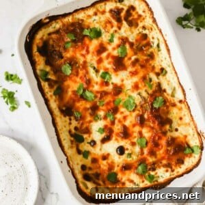A baking dish full of cheesy scalloped potatoes topped with cilantro.