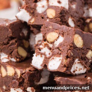 Slices of rich Rocky Road Fudge, showcasing its enticing layers of chocolate, marshmallows, and almonds.