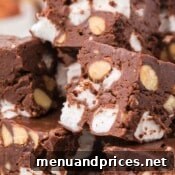 A close-up of a stack of rocky road fudge pieces, highlighting the texture and ingredients.