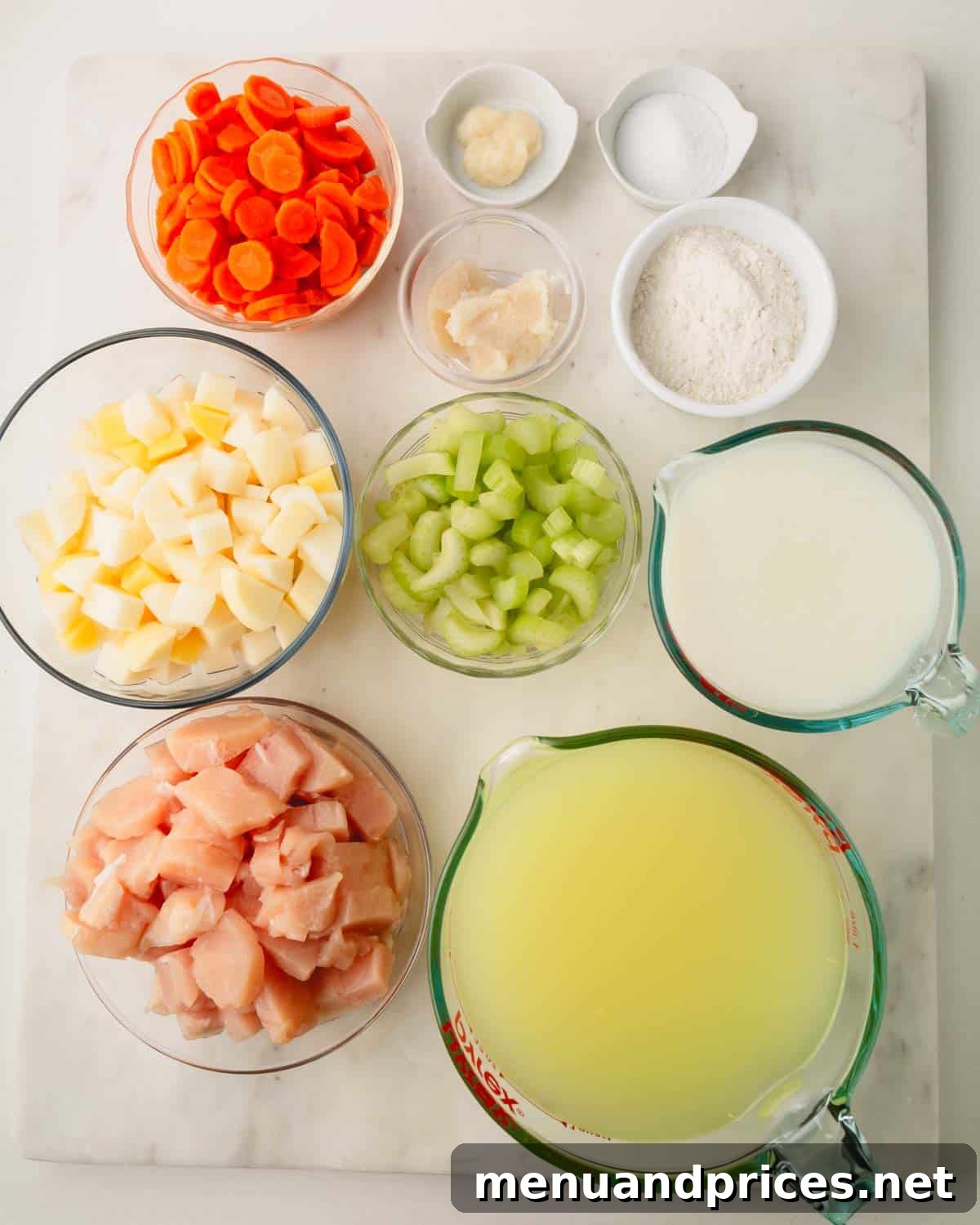 Pillowy Knoephla Noodle Soup 7 A vibrant selection of ingredients for knoephla soup, neatly arranged in individual bowls, ready for cooking.