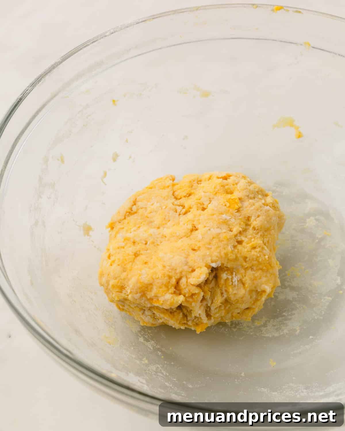 Pillowy Knoephla Noodle Soup 9 Roughly mixed knoephla dough has begun to form a shaggy ball within a glass mixing bowl.