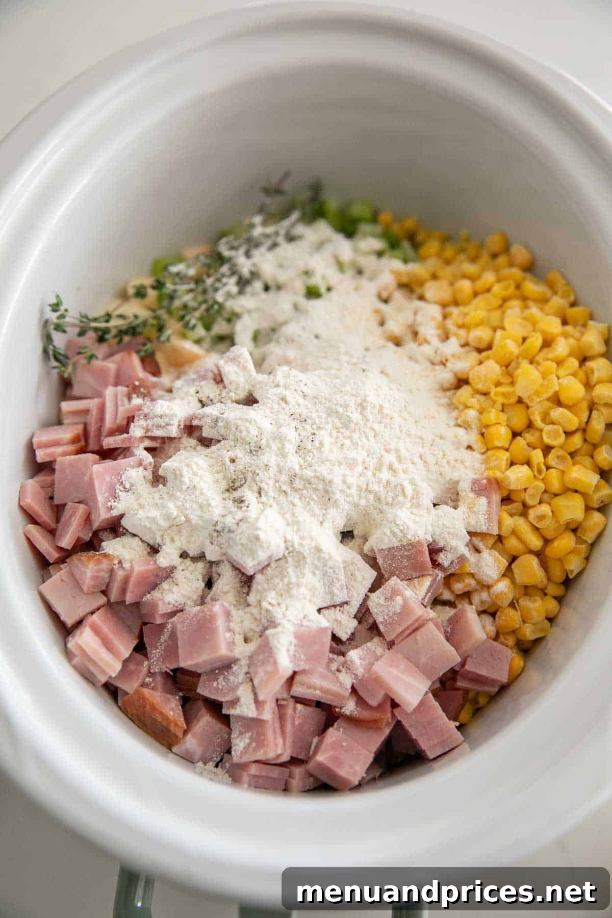 Hearty Slow Cooker Ham and Potato Chowder 5 A slow cooker bowl with the ingredients for ham and potato soup.