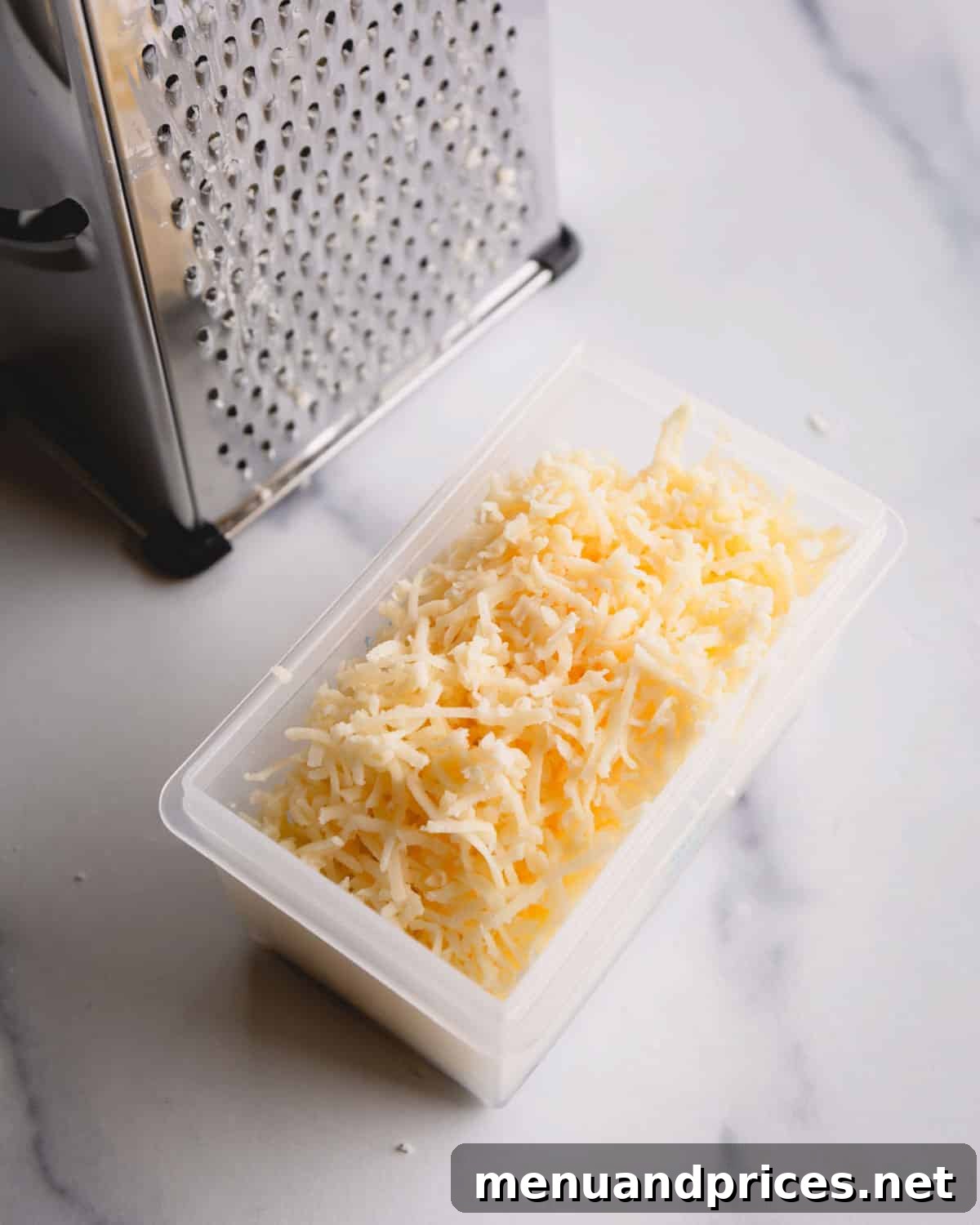 Fluffy Havarti Cheese Gougères 7 Close-up of freshly grated aged Havarti cheese on a fine grater, ready for the dough.