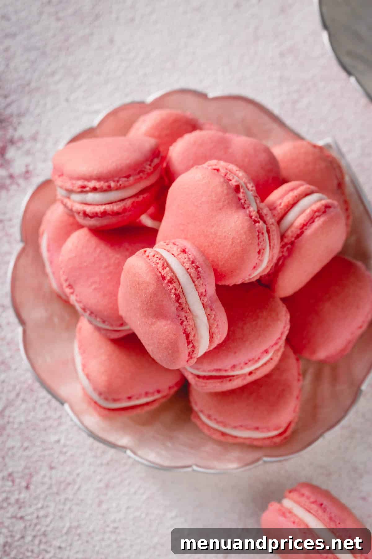 A stack of perfectly piped pink heart macarons, ready to be enjoyed.