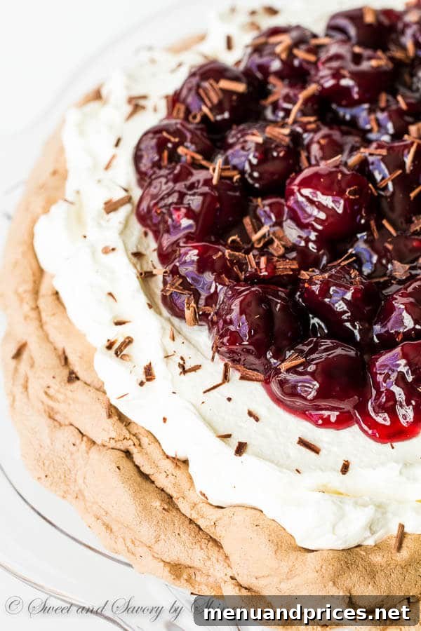 Velvet Cherry Chocolate Pavlova 3 A close-up shot of a magnificent Chocolate Pavlova, showcasing its crisp exterior and soft, cloud-like interior, generously topped with glistening sweet cherry sauce.