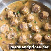 A close-up of the delicious beef meatballs and mushroom gravy in a rustic bowl.
