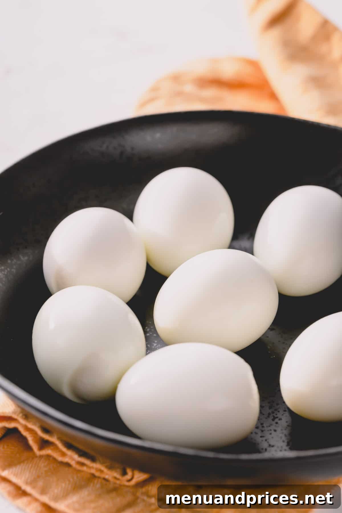 Perfectly Peelable Farm Fresh Eggs 3 Peeled hard boiled eggs on a white plate.