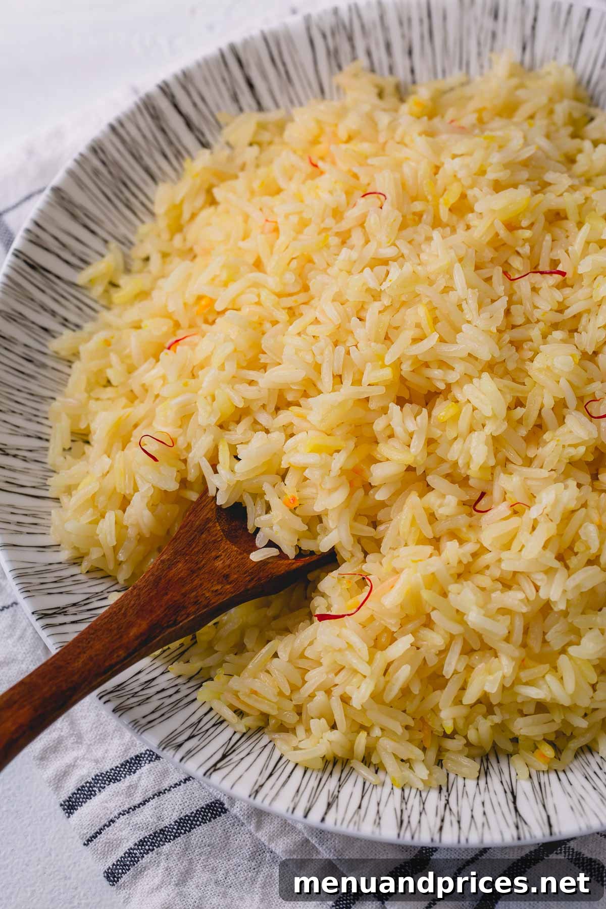 Sun-Drenched Saffron Rice 10 Saffron rice in bowl with wooden spoon