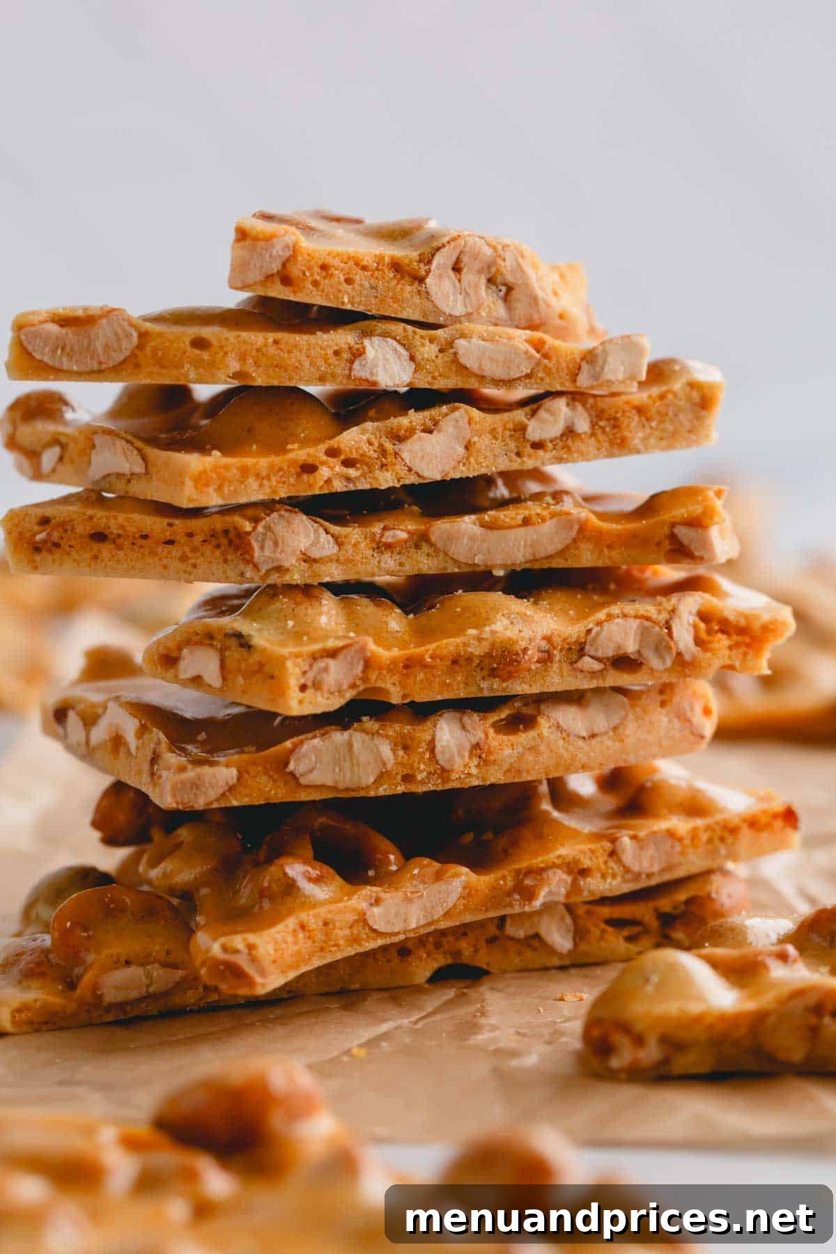 A stack of golden, crunchy microwave peanut brittle pieces, perfectly broken.