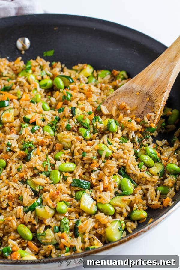 Flavorful Vegetable Fried Rice 3 A close-up of a bowl of homemade vegetable fried rice, showcasing fluffy jasmine rice, diced sweet potatoes, vibrant zucchini, and green edamame.