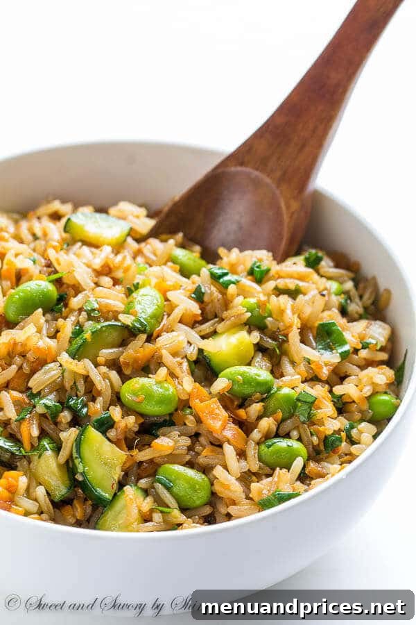 Flavorful Vegetable Fried Rice 4 A generous serving of fresh vegetable fried rice with sweet potato and zucchini, garnished with fresh scallions, ready to be enjoyed.