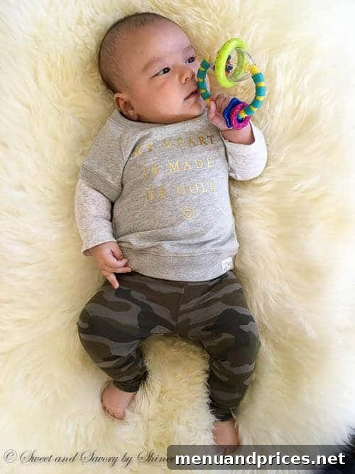 Baby Grant Three Month Milestones 5 Baby Grant holding and playing with a colorful toy, showcasing his developing fine motor skills.