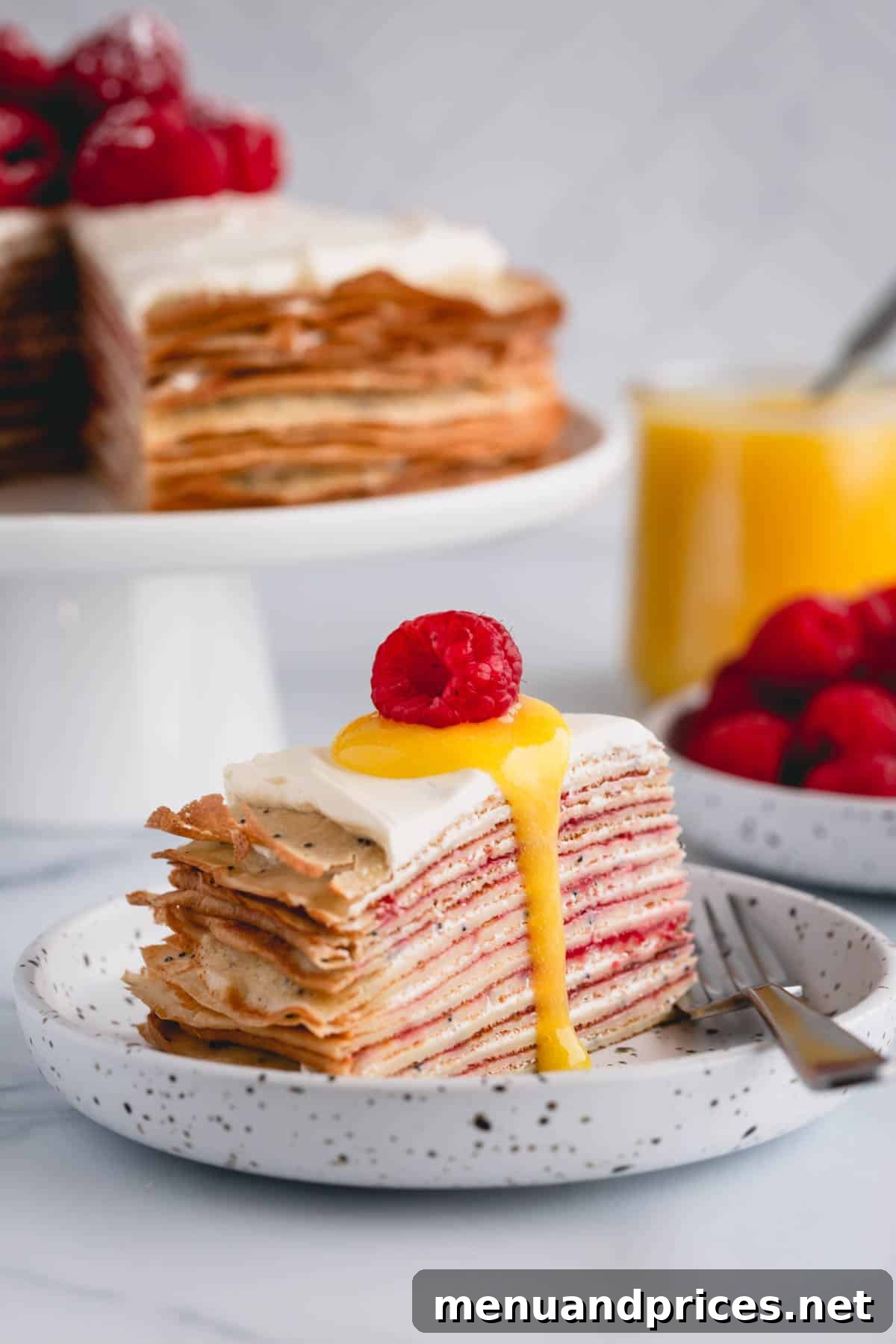 Zesty Lemon Raspberry Crepe Tower 3 A perfect slice of lemon raspberry crepe cake, revealing multiple thin layers of crepe and filling, topped with a dollop of lemon curd and fresh raspberries.