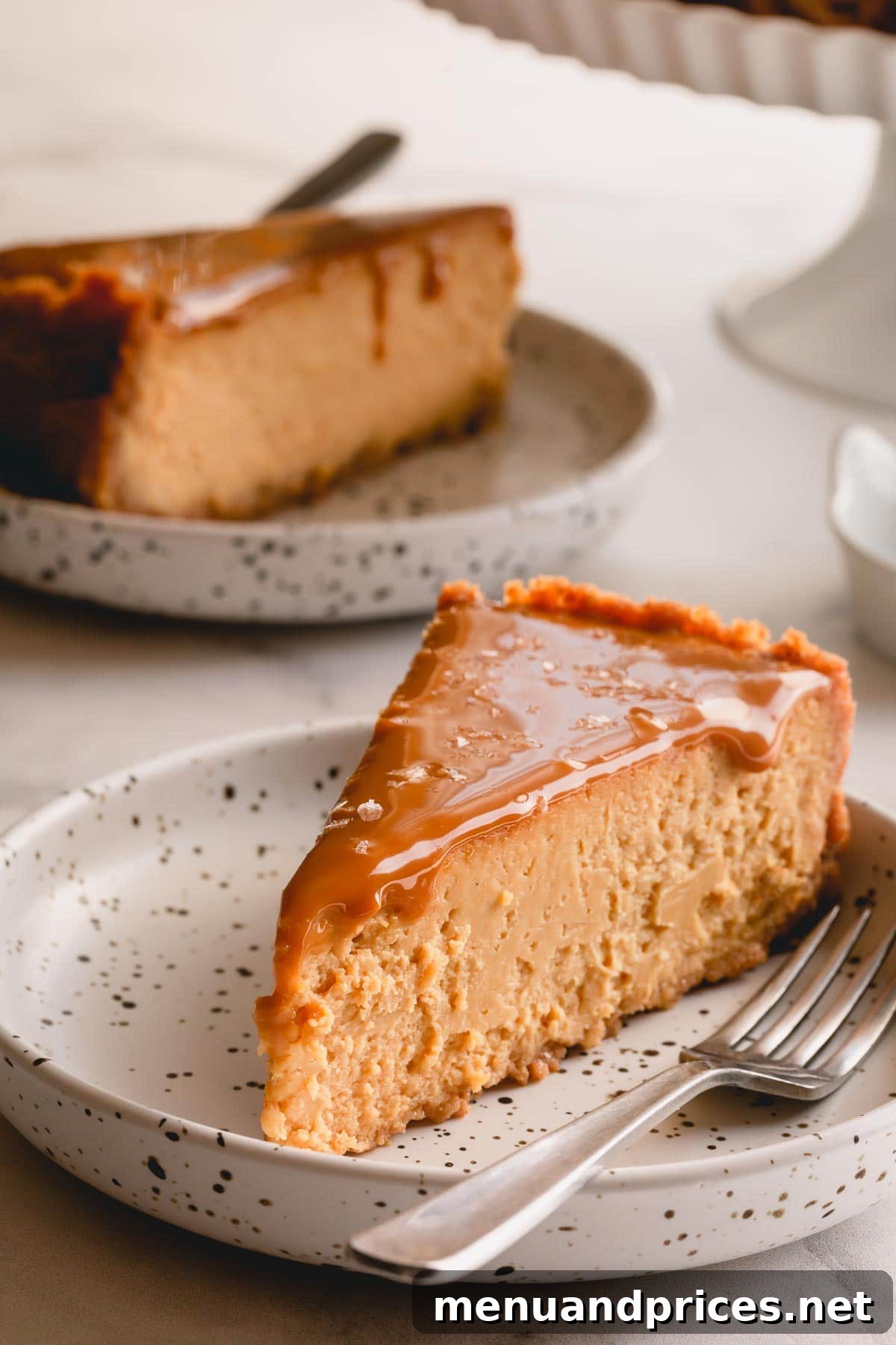 A beautifully presented slice of Dulce de Leche Cheesecake on a small plate, ready to be enjoyed, hinting at its deliciousness and shareability.