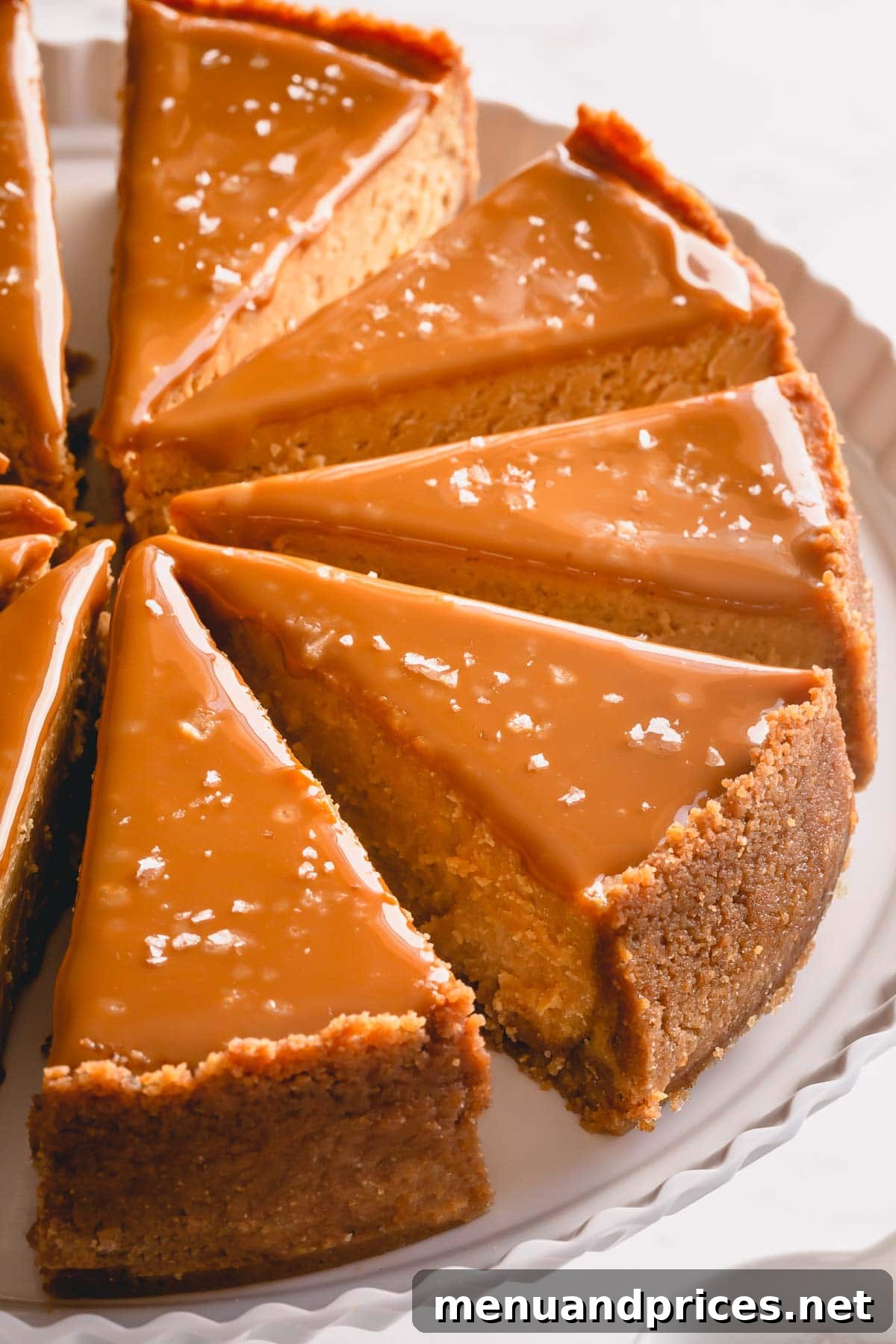 A large serving platter holding a whole, exquisitely decorated Dulce de Leche Cheesecake, ready to be served.