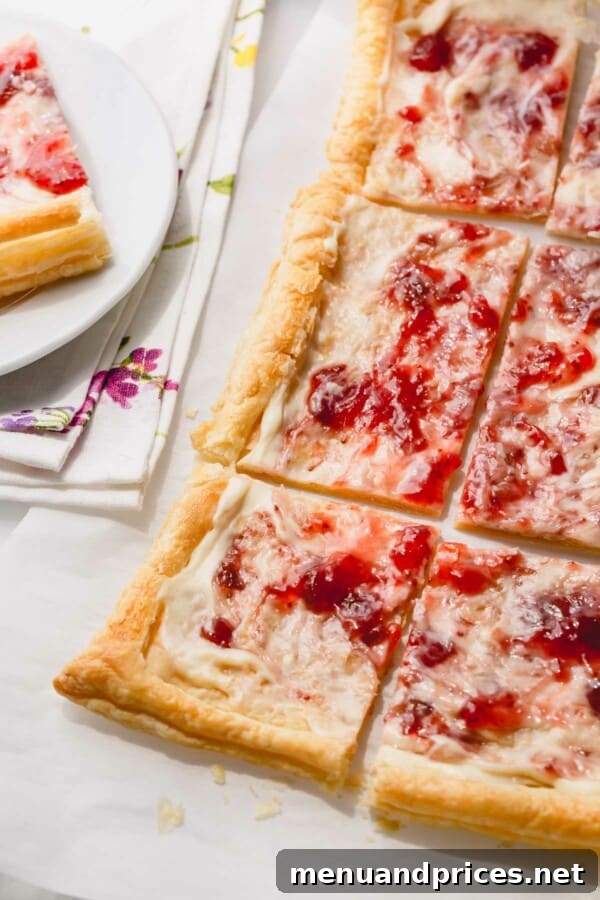 Close-up of golden, flaky puff pastry crust on a baking sheet, with a scored border, ready for the filling.