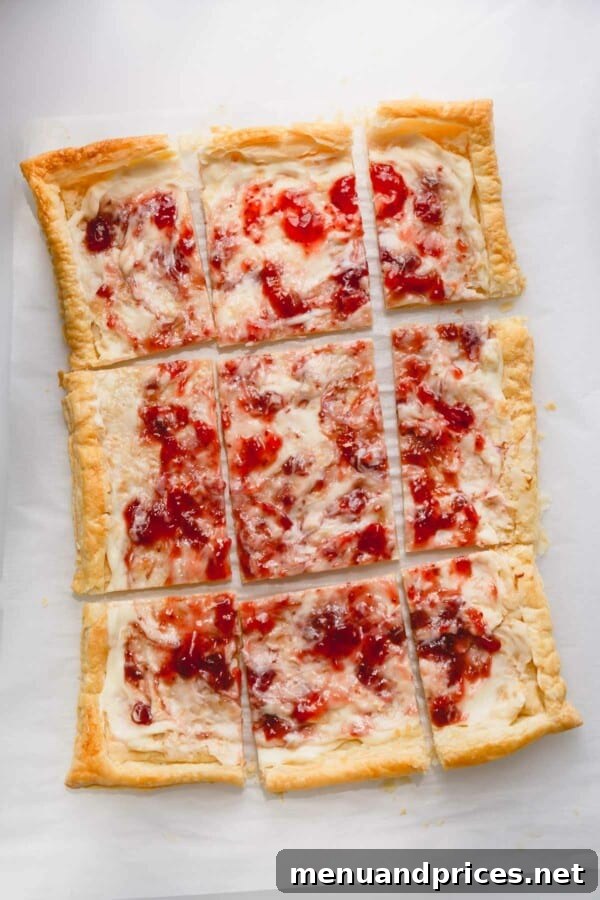 Freshly baked strawberry cheesecake tart, sliced and garnished with fresh strawberries and a dusting of powdered sugar, ready to eat.