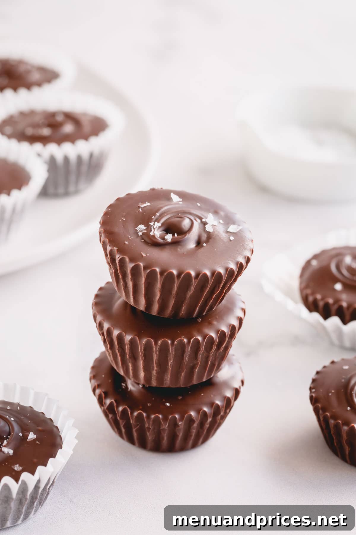 Gourmet Chocolate Caramel Indulgence 5 Three chocolate cups with a decorative sprinkle of salt flakes, beautifully arranged in a stacked formation.