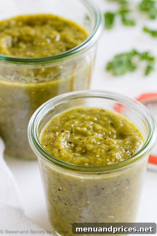 Ember-Kissed Tomatillo Salsa 3 Two glass jars filled with homemade charred tomatillo salsa verde, ready for storage or serving.
