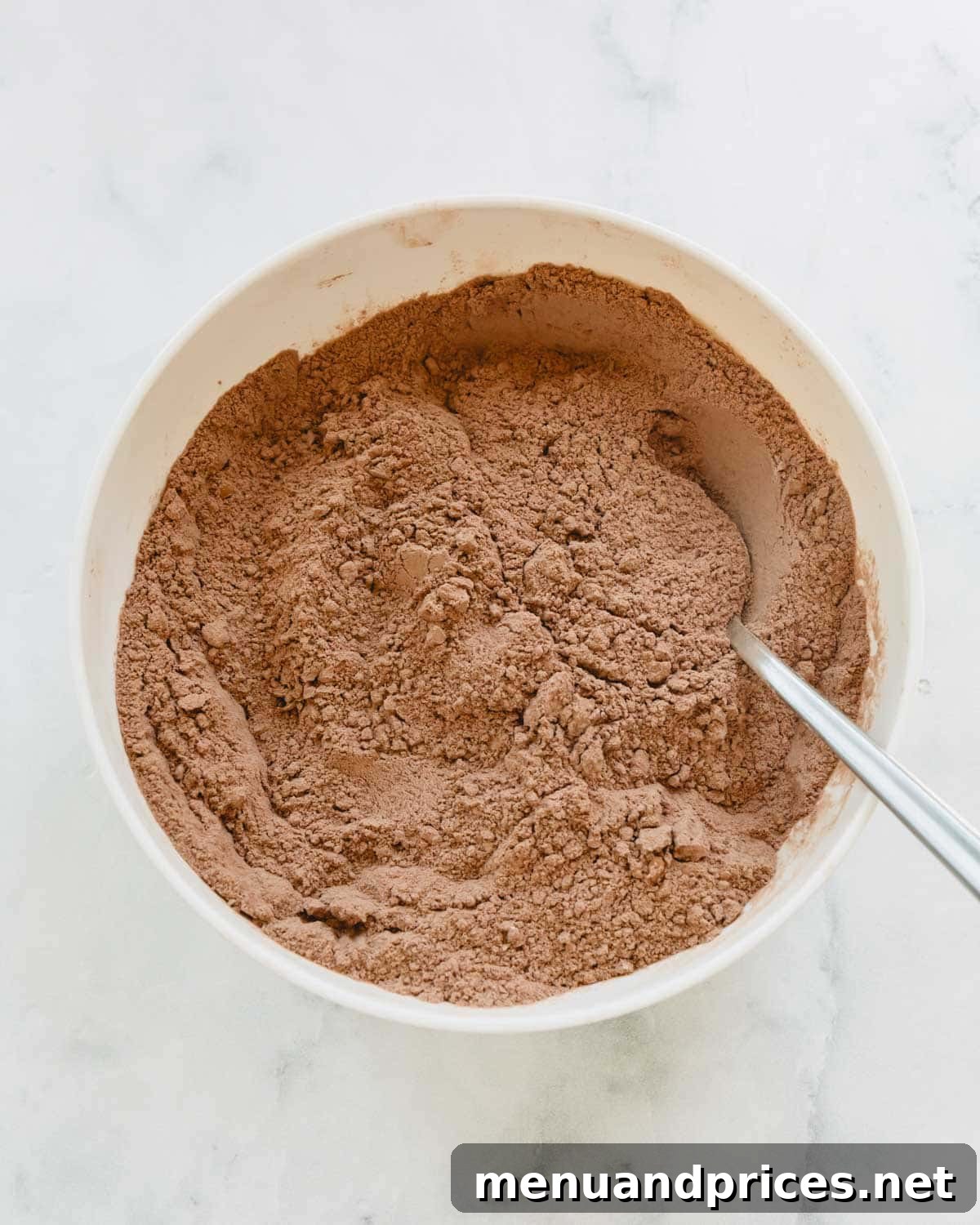 Fudgy Chocolate Zucchini Sheet Cake 4 Dry ingredients for chocolate zucchini cake batter being whisked together in a large bowl.