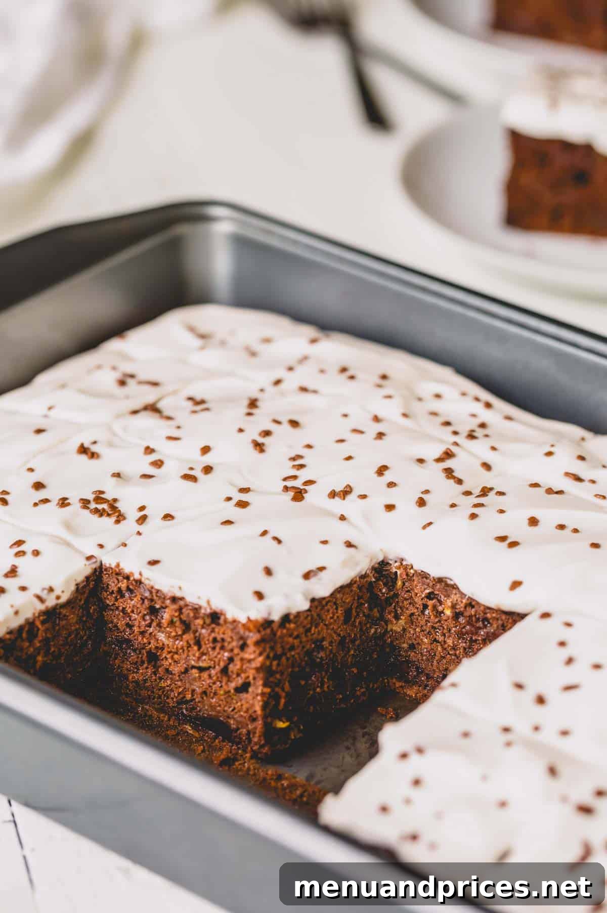 Fudgy Chocolate Zucchini Sheet Cake 9 Double chocolate zucchini cake in a pan with several slices already enjoyed.