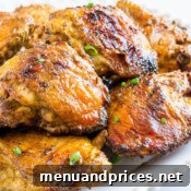 Grilled curry chicken thighs on a plate with rice, ready to be served