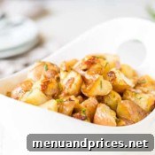 A bowl of Instant Pot Bacon Ranch Potatoes, garnished with fresh herbs