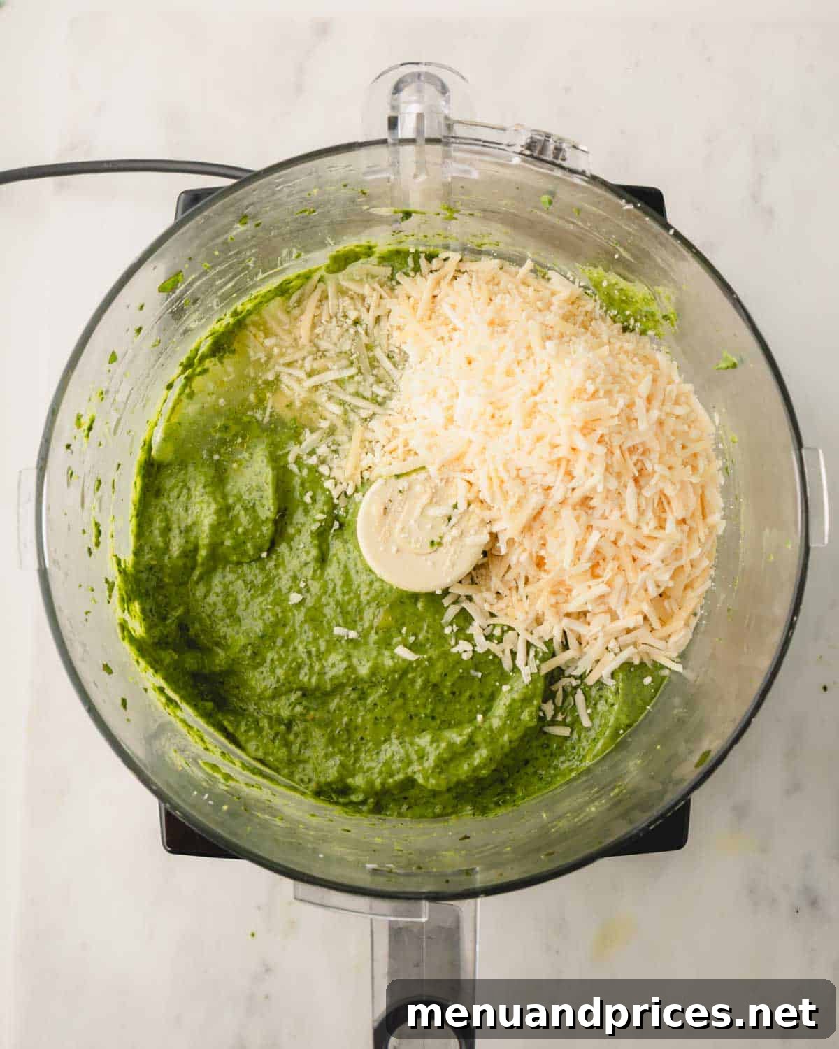 Big Batch Basil Pesto: A Freezer-Friendly Recipe 12 Grated Parmesan cheese on top of the pesto mixture in the food processor, prior to final blending.