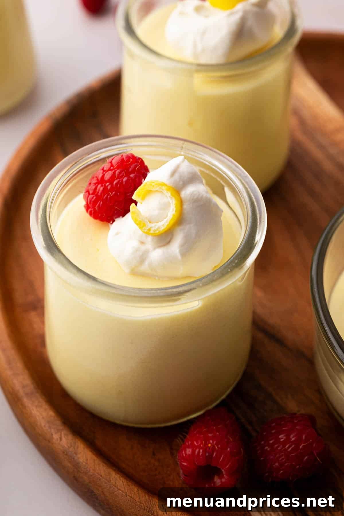 Zesty Lemon Dream 2 Lemon mousse in a small glass jar on a wooden board.