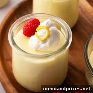 Lemon mousse in a small glass jar on a wooden board.