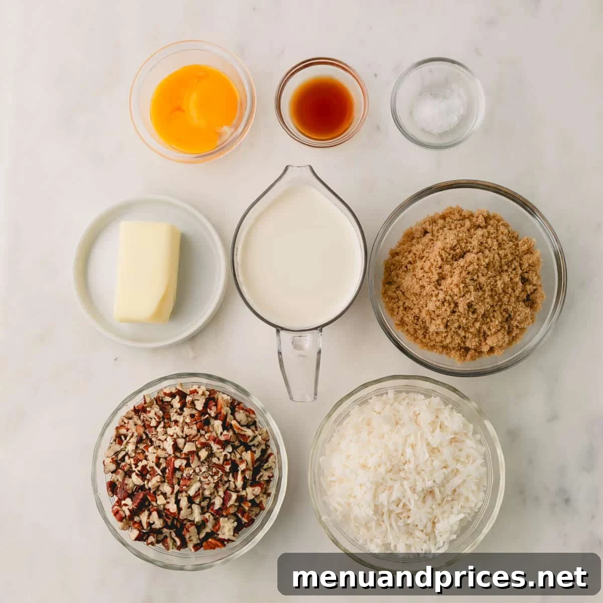 Ingredients laid out for making coconut pecan frosting, including pecans, coconut flakes, eggs, brown sugar, and butter.