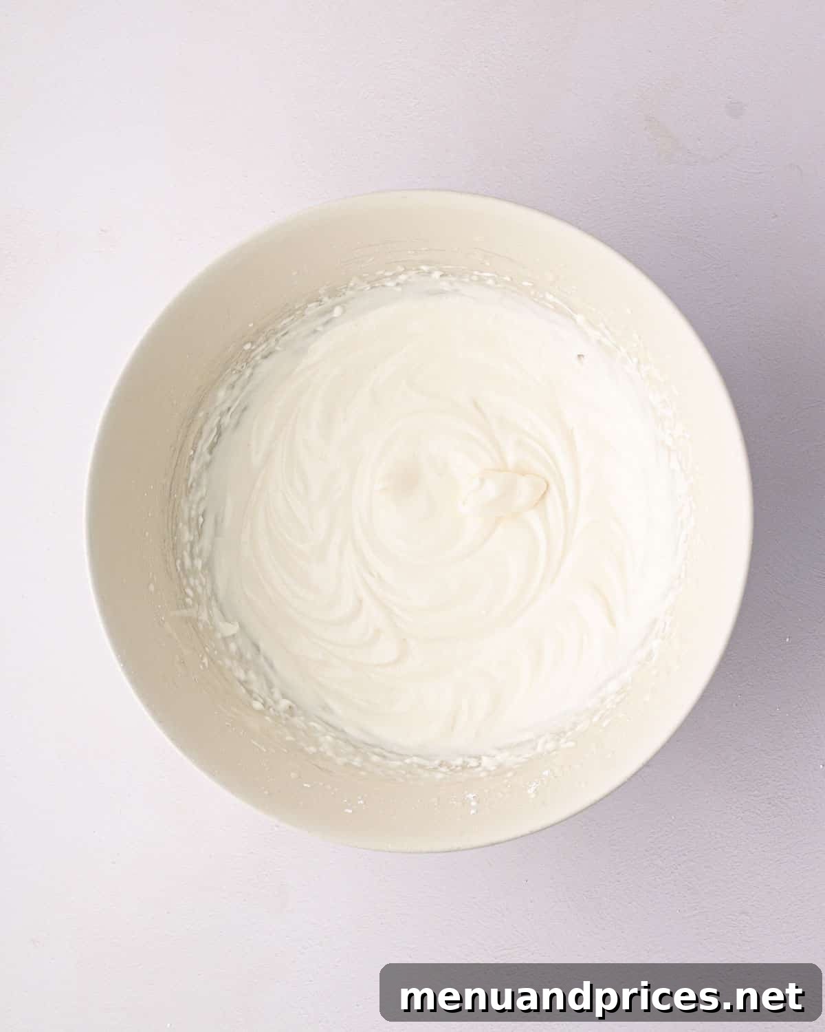 Bright Citrus Tiramisu 12 The heavy whipping cream mixture after being whipped to soft peaks in a white bowl.