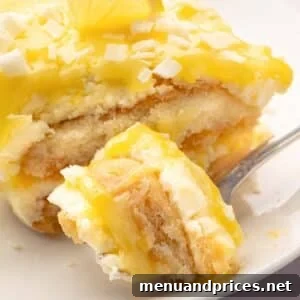 A fork taking a bite out of limoncello tiramisu with a slice on a white plate.