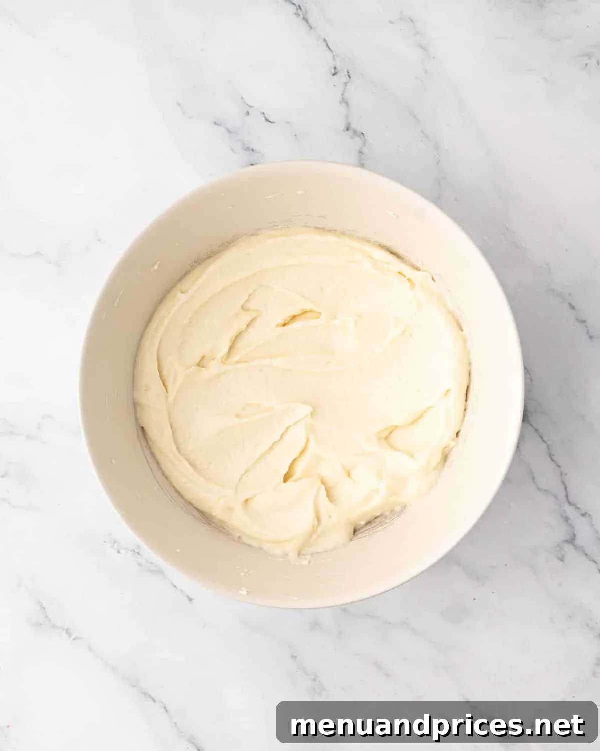 Smooth and creamy whipped mascarpone and vanilla mixture in a white bowl.