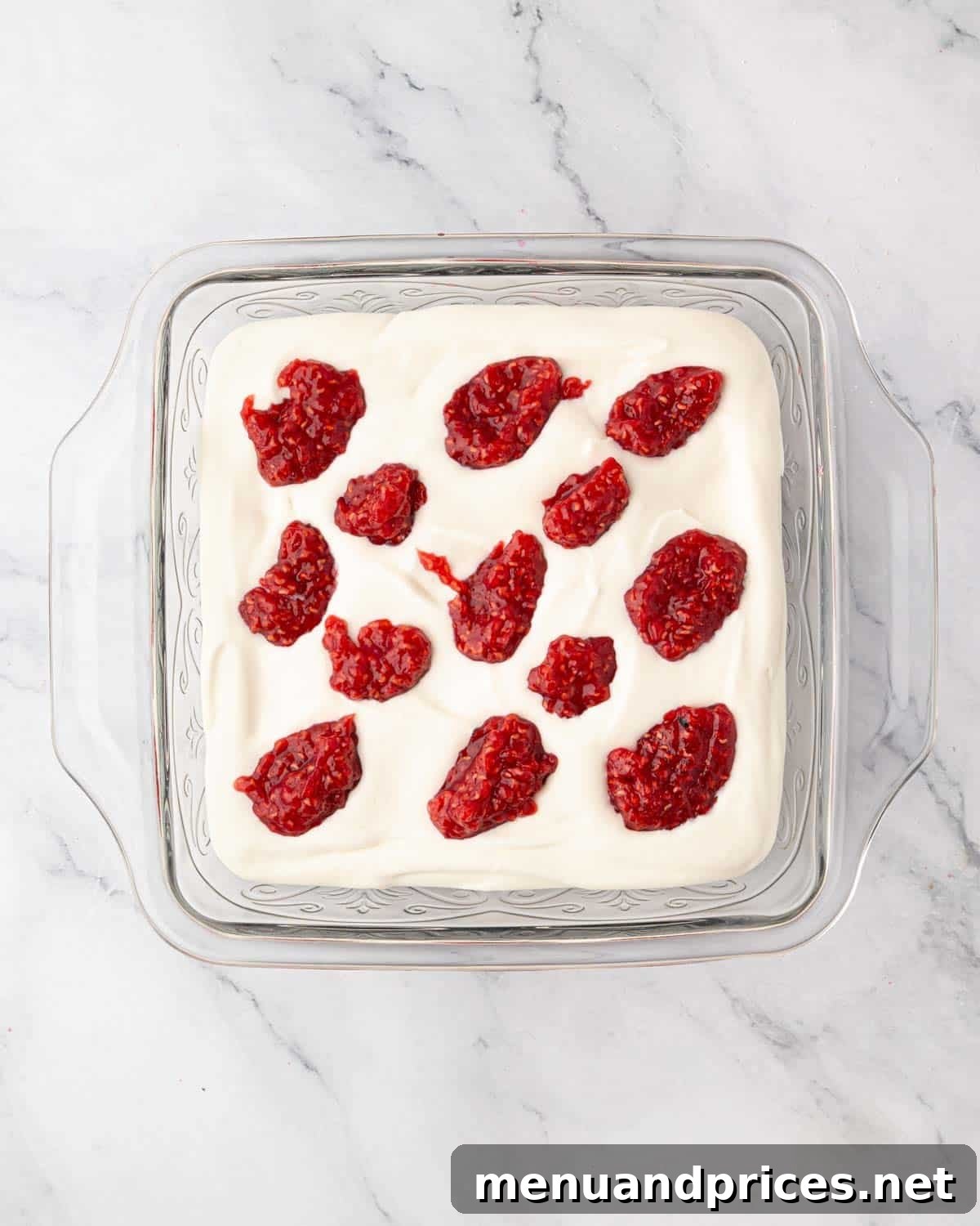 Small dollops of raspberry compote delicately placed over the mascarpone cream.