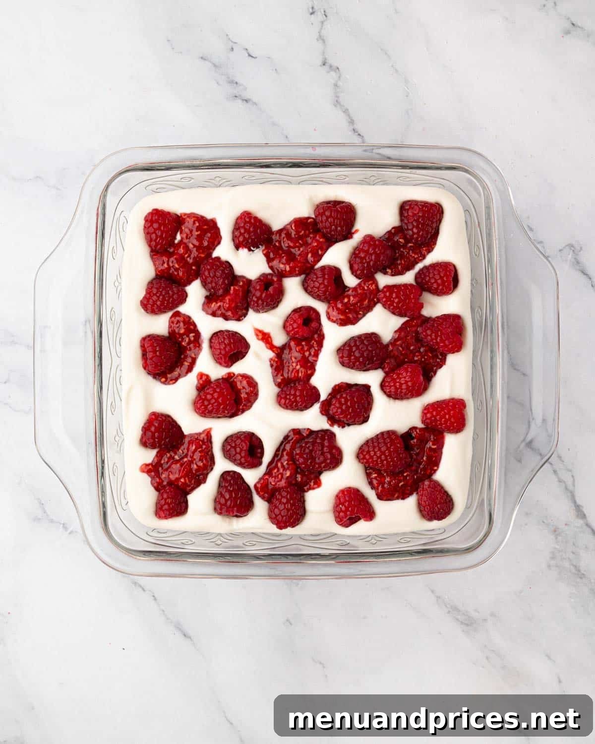 A vibrant layer of raspberry compote and fresh raspberries atop the mascarpone cream.