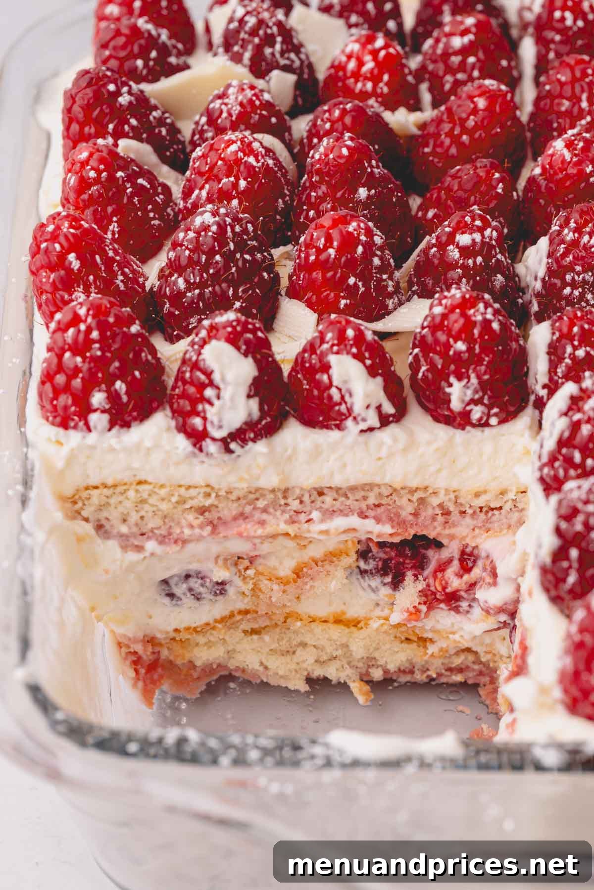 Close up image of a clean slice taken out of raspberry tiramisu, revealing the perfect layers.